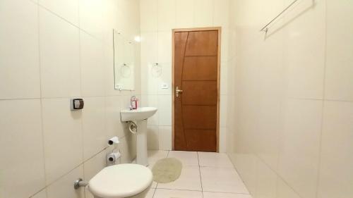 a white bathroom with a toilet and a sink at Rancho Santana in Socorro