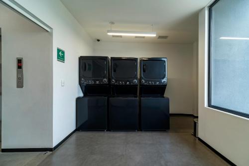 a room with three large windows in a building at Stadía Suites Querétaro Centro Histórico in Querétaro