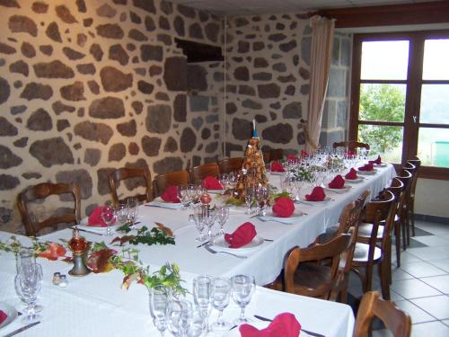 a long dining table with red roses on it at Auberge Hôtel de Tournemire - Cantal in Tournemire