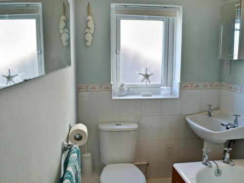 ビードネルにあるDunstanburgh Viewのバスルーム(トイレ、洗面台付)、窓が備わります。