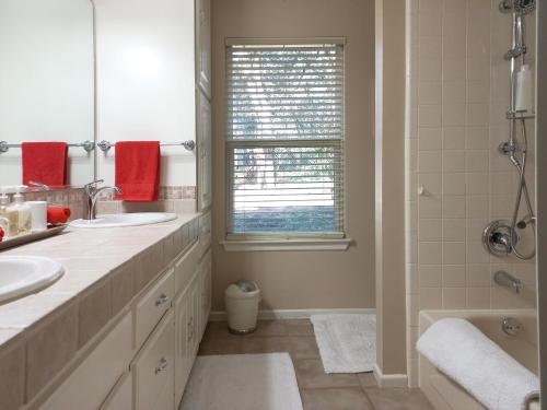 a white bathroom with two sinks and a shower at King Bed in Relaxing Oasis, with FREE Snack/Wi-Fi/Parking in San Marcos