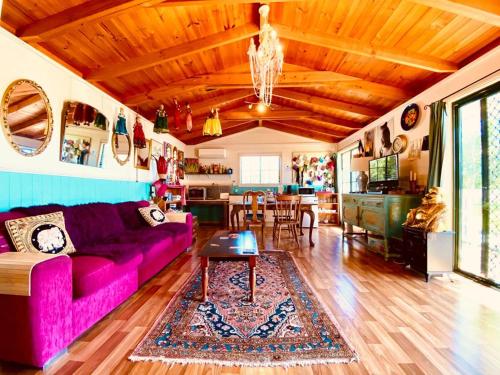 a living room with a purple couch and a kitchen at The Bohemian Art Studio in Creswick