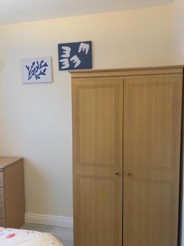 um quarto com um armário de madeira ao lado de uma cama em One Bedroom Apartment Dublin em Dublin