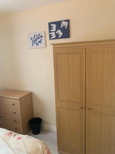 a bedroom with a bed and a wooden cabinet at One Bedroom Apartment Dublin in Dublin