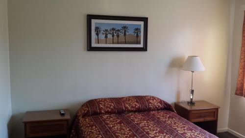 a bedroom with a bed and a picture on the wall at Lido Hotel in Huntington Park