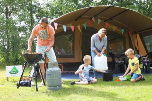 a man and a woman and two children in front of a tent at Charmecamping & Appartementen De Regge-Vallei in Den Ham