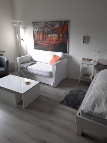 Sala de estar con sofá blanco y mesa de centro en Happy Living en Mülheim an der Ruhr