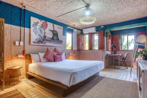 a bedroom with a large white bed and blue walls at Selina Cancun Laguna Hotel Zone in Cancún