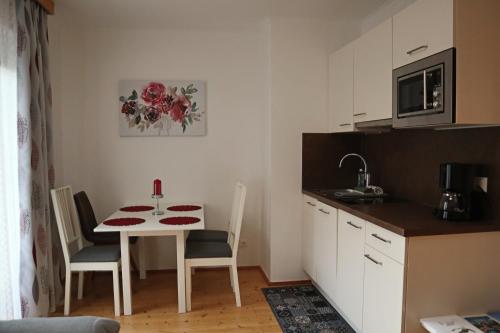 a small kitchen with a small table and a table and chairs at Landhaus-Appartements Warraich in Schladming
