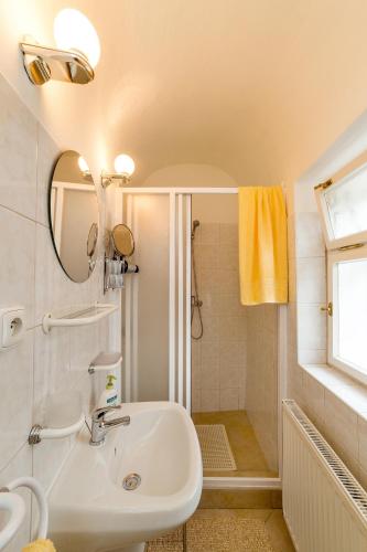 un bagno bianco con lavandino e specchio di Pension U Kapličky a Cesky Krumlov