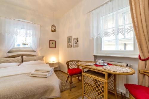 una camera da letto con un letto, un tavolo e una finestra di Pension U Kapličky a Cesky Krumlov