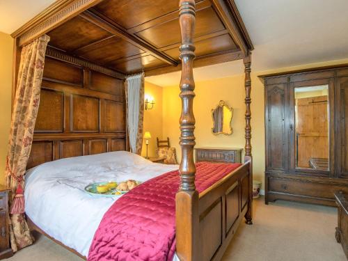 ein Schlafzimmer mit einem großen Himmelbett mit einer roten Decke in der Unterkunft The Thatch in South Willingham