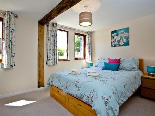 sypialnia z łóżkiem z niebieską kołdrą w obiekcie Bluetit Cottage w mieście Kings Nympton