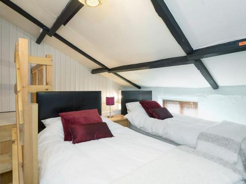 two beds in a room with white and red pillows at Horseshoe House - Ukc2743 in Watton