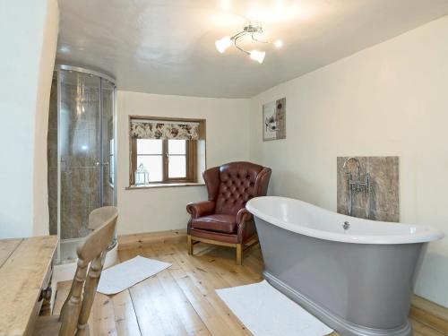 un ampio bagno con vasca e sedia di Horseshoe House - Ukc2743 a Watton