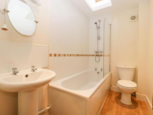 Un baño con lavabo, bañera e inodoro. en 9 Malthouse Court, en Watchet