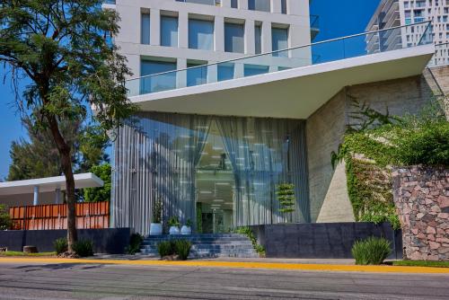 um edifício de escritórios com uma fachada de vidro em Park Life Guadalajara em Guadalajara