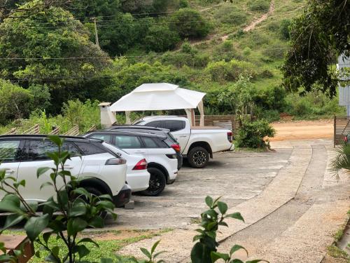 um grupo de carros estacionados num parque de estacionamento com uma tenda em Pousada Rosa Bonita na Praia do Rosa