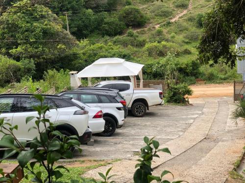 a group of cars parked in a parking lot with a tent at Pousada Rosa Bonita in Praia do Rosa