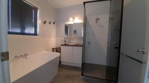 uma casa de banho com banheira e chuveiro em Cherry Mango Guesthouse em Apple Tree Creek