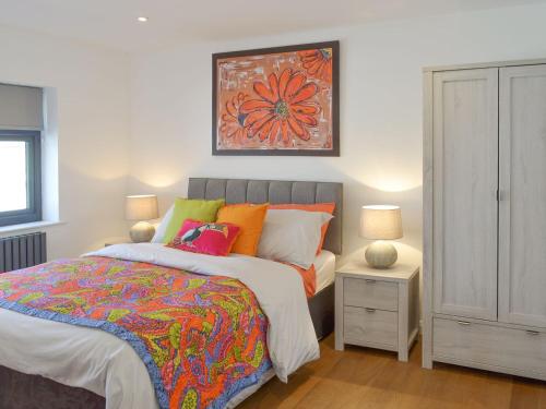 a bedroom with a bed and a painting on the wall at Deepwater Point Apartment in Torquay