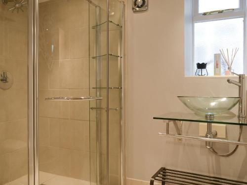 a bathroom with a glass shower with a sink at The Dun Cow in Bishop Middleham