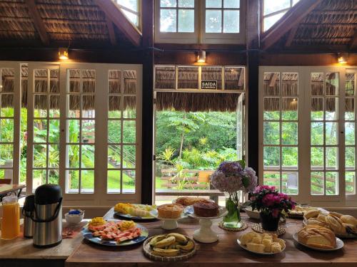 uma mesa com pratos de comida com janelas em Espaço Verde Novo Chalés em Teresópolis