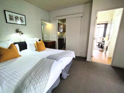 a hotel room with two beds and a hallway at Whispering Sands Beachfront Motel in Gisborne