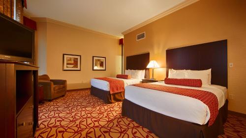 ein Hotelzimmer mit 2 Betten und einem Flachbild-TV in der Unterkunft Best Western Park Hotel in Warren