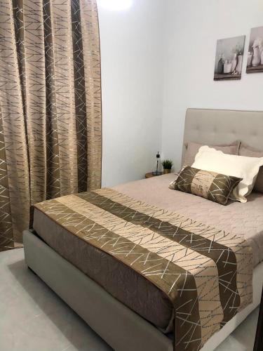 a bedroom with a bed with a brown bedspread and curtains at VC Alojamentos T2 in Seia