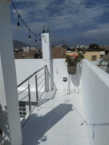 a balcony with a pot of flowers on a roof at Ambigua Hospedaje in Trujillo