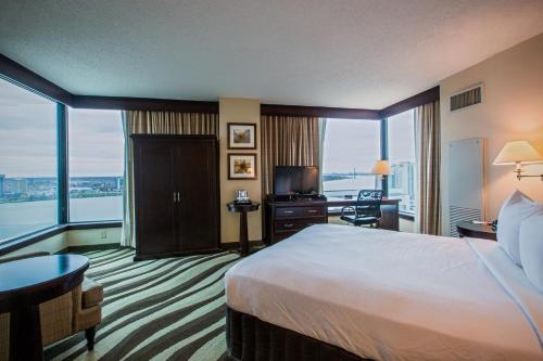 a hotel room with a bed and a large window at Fort Pontchartrain Detroit, a Wyndham Hotel in Detroit