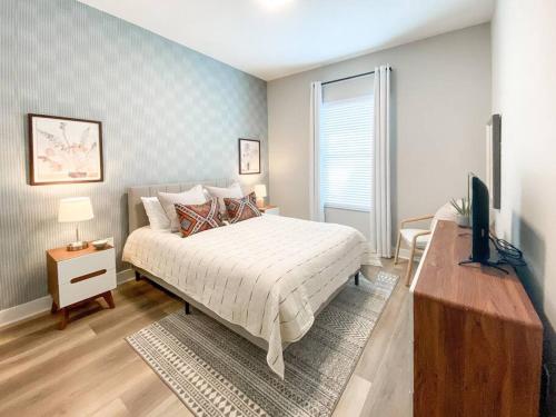 Un dormitorio con una cama y un televisor. en BRAND NEW 3 bedroom near DISNEY / Wi-Fi / Parking, en Orlando