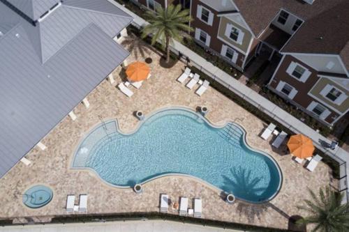 Una vista aérea de una piscina con sillas y sombrillas. en BRAND NEW 3 bedroom near DISNEY / Wi-Fi / Parking, en Orlando