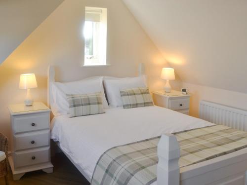 1 dormitorio con 1 cama blanca y 2 mesitas de noche en High Trees Annex, en Widdrington