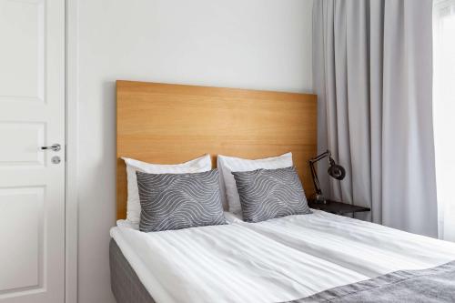 a bedroom with a bed with a wooden headboard and pillows at Sure Hotel by Best Western City Jonkoping in Jönköping