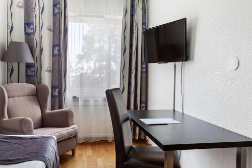 a room with a table and a tv and a chair at Sure Hotel by Best Western City Jonkoping in Jönköping