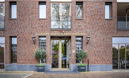 un edificio de ladrillo con un cartel que lee la biblioteca suite embajador en Luxury Suites Amsterdam, en Ámsterdam