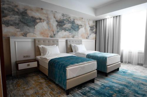 a hotel room with two beds and a mural at Best Western Plus Oskemen in Ustʼ-Kamenogorsk