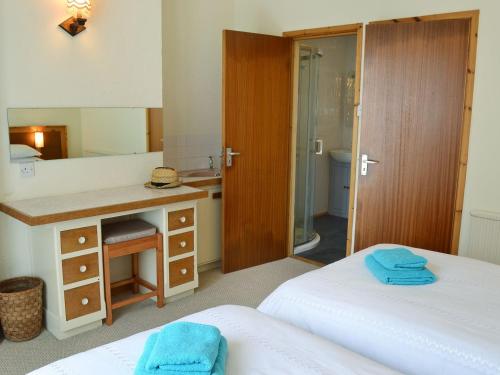 um quarto com 2 camas, uma secretária e um espelho. em Sowenna - Ukc3537 em Mevagissey