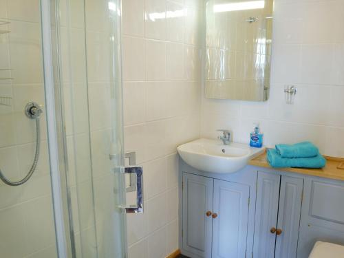 y baño blanco con lavabo y ducha. en Sowenna - Ukc3537, en Mevagissey
