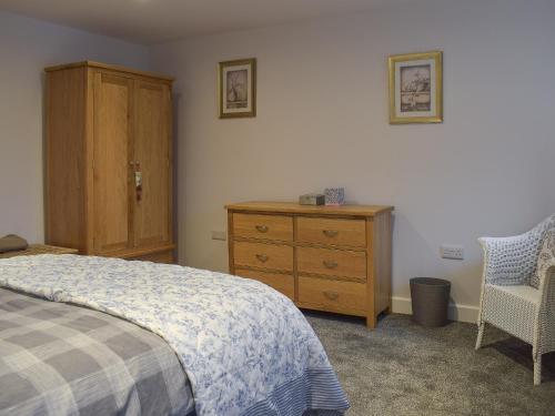 Un pat sau paturi într-o cameră la Rosemount Cottage