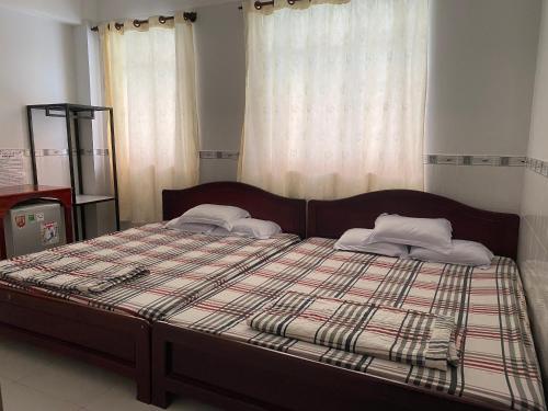a bed with two pillows on it in a bedroom at NHÀ NGHỈ NAM PHƯƠNG in Ha Tien