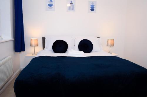 a bedroom with a black and white bed with two lamps at Modern 3 Bed House in Wolverhampton