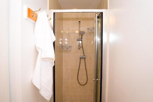 y baño con ducha y toalla blanca. en Modern 3 Bed House, en Wolverhampton