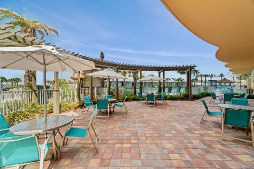 a patio with tables and chairs and umbrellas at Luxury Calypso Tower 3! Free Beach Chair Service for 4! by Dolce Vita Getaways PCB in Panama City Beach