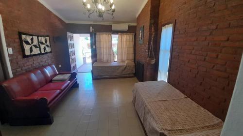 a living room with a couch and a brick wall at Apart Dany in Villa Los Molinos