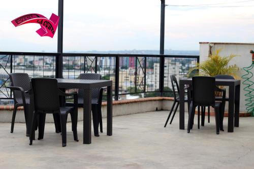 a group of tables and chairs on a balcony at La Curva Apartamentos in Cali