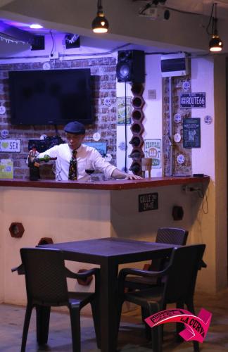 a man standing behind a bar with a table at La Curva Apartamentos in Cali