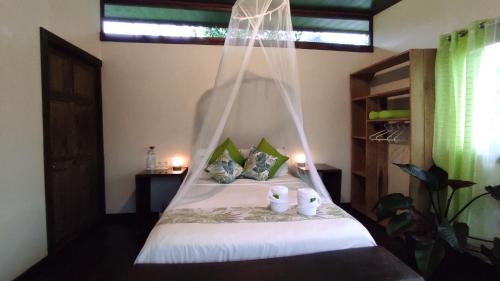 1 dormitorio con 1 cama con mosquitera en EYA Ecolodge, en San Isidro